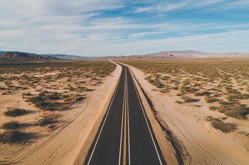 Fototapeta premium Aerial view of an empty asphalt road through the desert