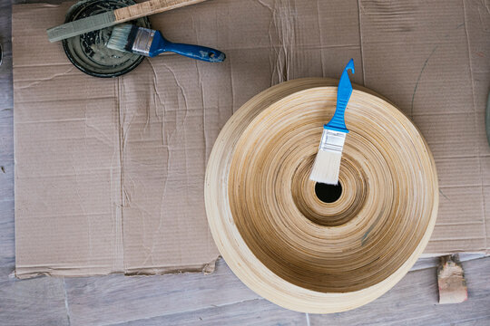 Artisan Painting Tools with Wooden Sculpture on Cardboard Surface