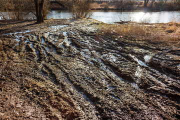 River bank with dirty mess and garbage in early spring