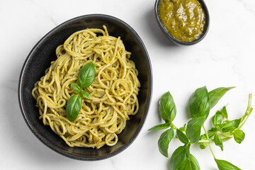 Italian pasta with pesto sauce and basil