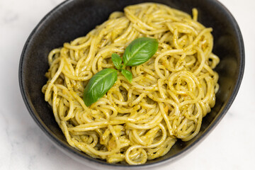 Italian pasta with pesto sauce and basil