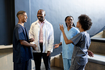Healthcare diverse professionals in scrubs and lab coat discussing in hospital, at conference hall
