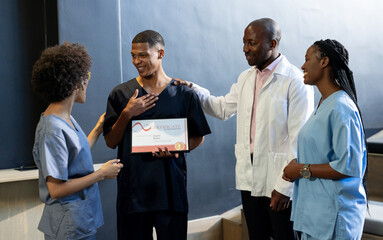 Celebrating colleague's achievement, medical diverse team in hospital hallway, at conference hall