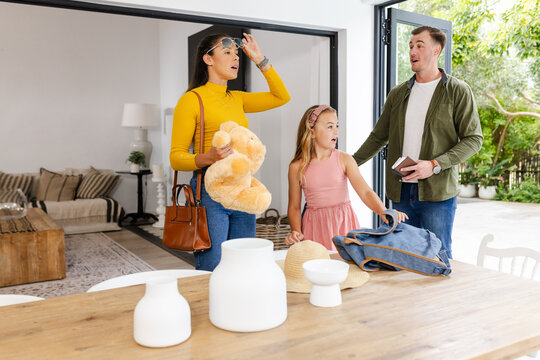 Family preparing for outing, packing bags and holding teddy bear at home
