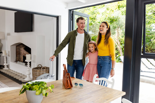 Happy family entering modern home, smiling and enjoying quality time together