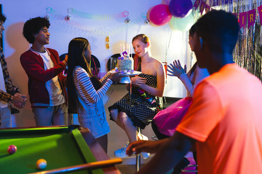Celebrating birthday with cake and balloons, Teenage friends smiling in party room, at home