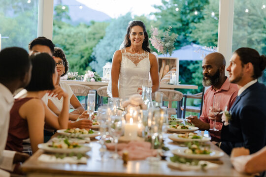 Bride smiling with guests at elegant wedding reception dinner table