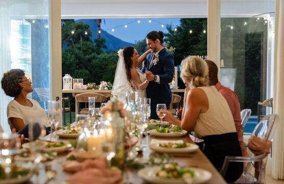 Bride and groom dancing joyfully at wedding reception with guests watching - Powered by Adobe