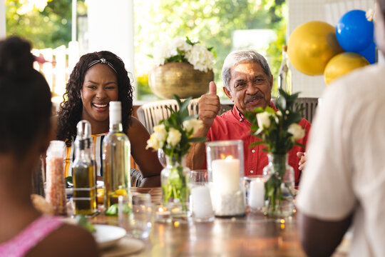 Having conversation during diverse family gathering , in garden