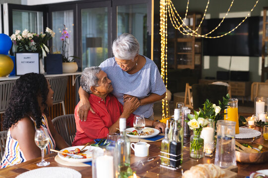 Celebrating retirement, grandparents with diverse family sharing joyful moments, in garden