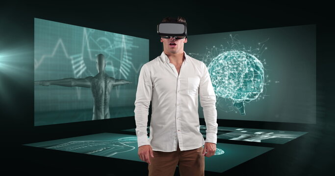 Image of businessman wearing vr headset over screens with medical data processing