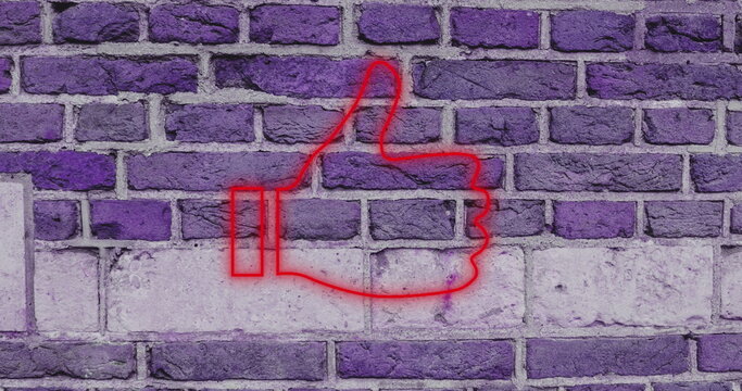 Neon red thumbs up sign glowing against purple brick wall background