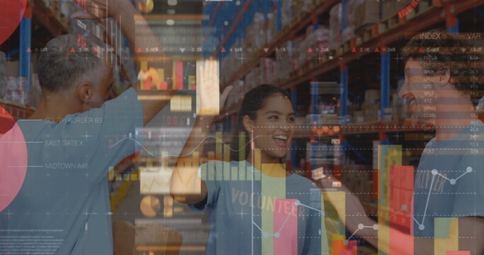Screens with data processing against male and female volunteers high fiving each other at warehouse