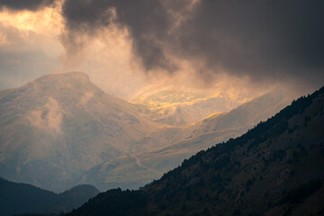 Sunlight breaking through mountain storm clouds in the Pyrenees