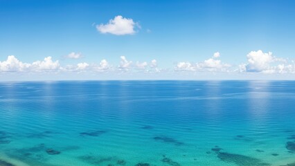 Fototapeta premium Tranquil ocean view with turquoise water and clear blue sky with clouds