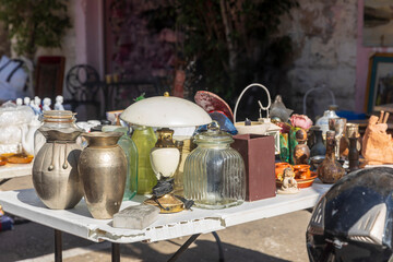 Barcelona, Spain, November 23, 2024, Assortment of vintage items for sale on a white table at an outdoor market