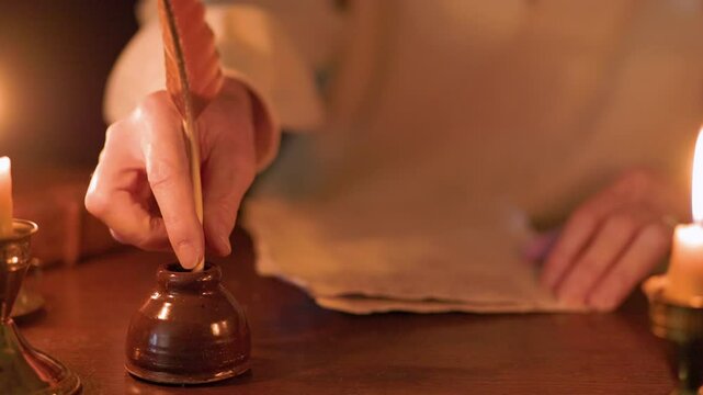 18th century man writing with a quill pen at his desk