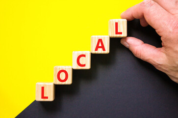 Local symbol. Concept word Local on beautiful wooden blocks. Beautiful yellow and black background. Businessman hand. Business lifestyle local concept. Copy space.