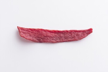 solitary tantalizing beef jerky strip lies on pristine white background offering ample copy space around it for text