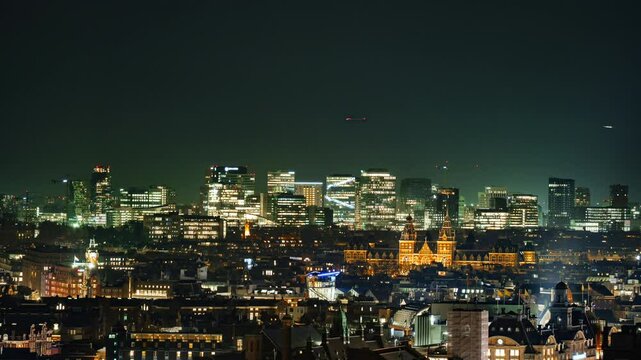 The illuminated skyline of Amsterdam's Zuidas district at night, featuring modern skyscrapers, corporate offices, and a dynamic financial hub blending contemporary architecture with urban vibrancy.