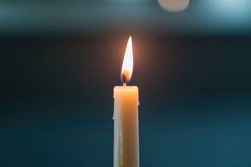 Fototapeta premium close-up of burning candle in dark room during vesak day meditation ceremony soft warm light illuminating wax