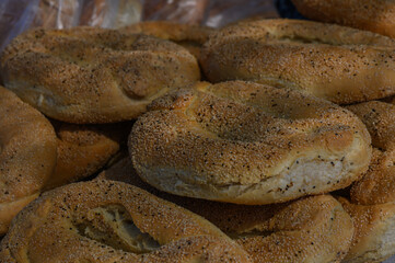 Freshly baked bagels piled high, showcasing their golden crusts and sprinkled toppings in a local bakery during the morning rush