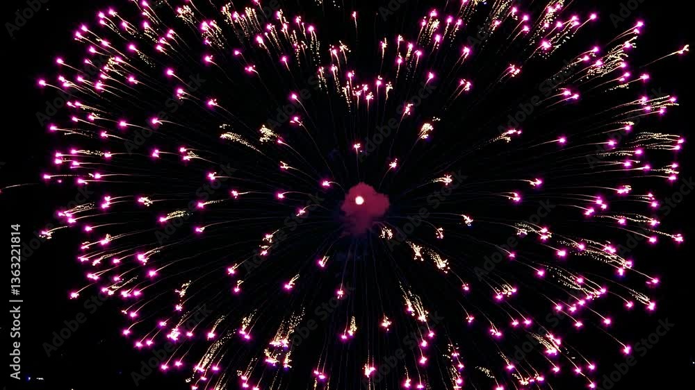Poster aerial view of vibrant heart-shaped fireworks exploding against a dark sky, captured in a dynamic, c