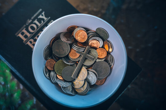 Coins with Holy Bible, a closeup, Christian biblical concept of tithing, Biblical concept of Christian offering