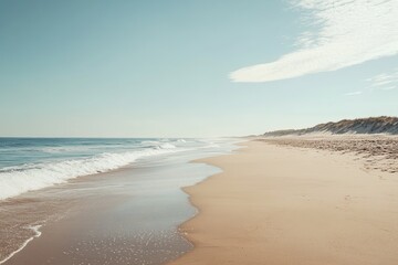 Obraz premium Beautiful sandy beach with gentle waves and clear blue sky in mid-afternoon