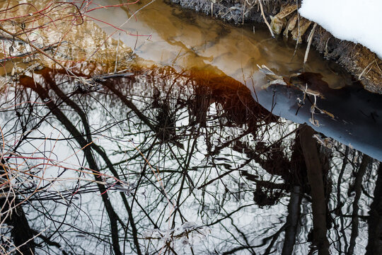 Fuels and grease in the water. Black oil in the river. Pollution