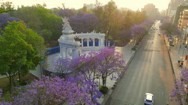Hemiciclo a juarez, landmark at alameda central in Mexico city, spring with pruple flower tree