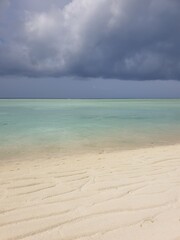 Tranquil Maldives Beach with Turquoise Water and Dramatic Sky