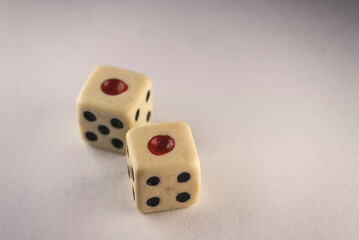 Two old dices on a white table close-up