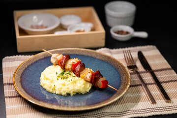 Typical czech cuisine chicken skewer with red pepper, onion, sausage and mashed potatoes