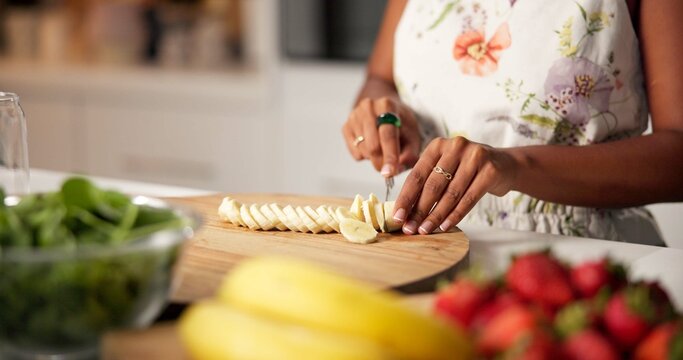 Woman, hands and cutting with banana for fruit salad, meal prep or healthy diet in kitchen at home. Closeup, female person or food preparation with natural organic snack for vitamins or nutrition