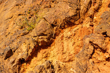 Eroded bauxite rock formation with bright orange colors in an abandoned bauxite mine
