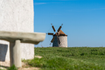 Rustic stone windmill in a grassy field © ZenitX