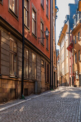Obraz premium Narrow cobbled street and colorful 17th- and 18th-century buildings in Stockholm Gamla stan (old town). Sweden