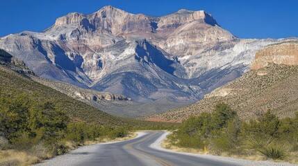 Fototapeta premium Scenic Mountain Landscape with Winding Road Under Clear Blue Sky in Nevada Desert Nature Adventure