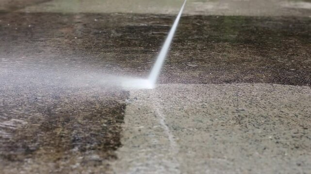 Using a power washer to clean concrete backyard flooring