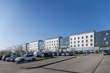 Modern building with parking lot on clear day Modern building with parking lot on clear day