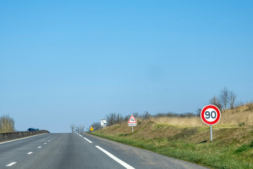 Speed limit signs along a highway on a clear day