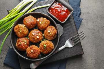 Tasty meatballs served on grey table, flat lay