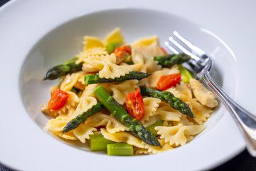 Farfalle pasta with green asparagus, cherry tomatoes and chicken