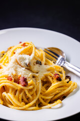 close up of spaghetti carbonara in white bowl
