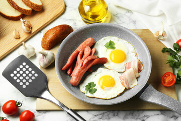 Tasty brunch. Fried eggs, sausages, bacon and other products on white marble table, above view