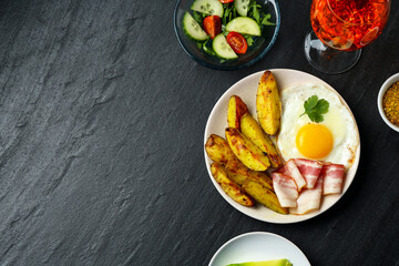 Flat lay composition with tasty brunch on dark textured table. Space for text