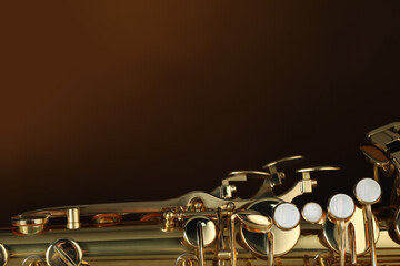 Obraz premium Jazz. One beautiful saxophone on brown background, closeup. Space for text