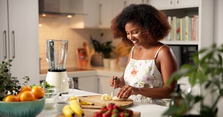 Woman, cut and fruit for smoothie at house of healthy ingredients, meal prep and nutrition drink. African, person and banana for organic beverage, vegan diet and weight loss benefits and detox recipe