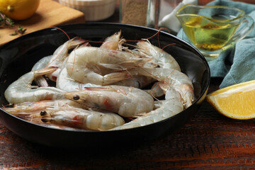 Fresh raw shrimps and spices on wooden table, closeup
